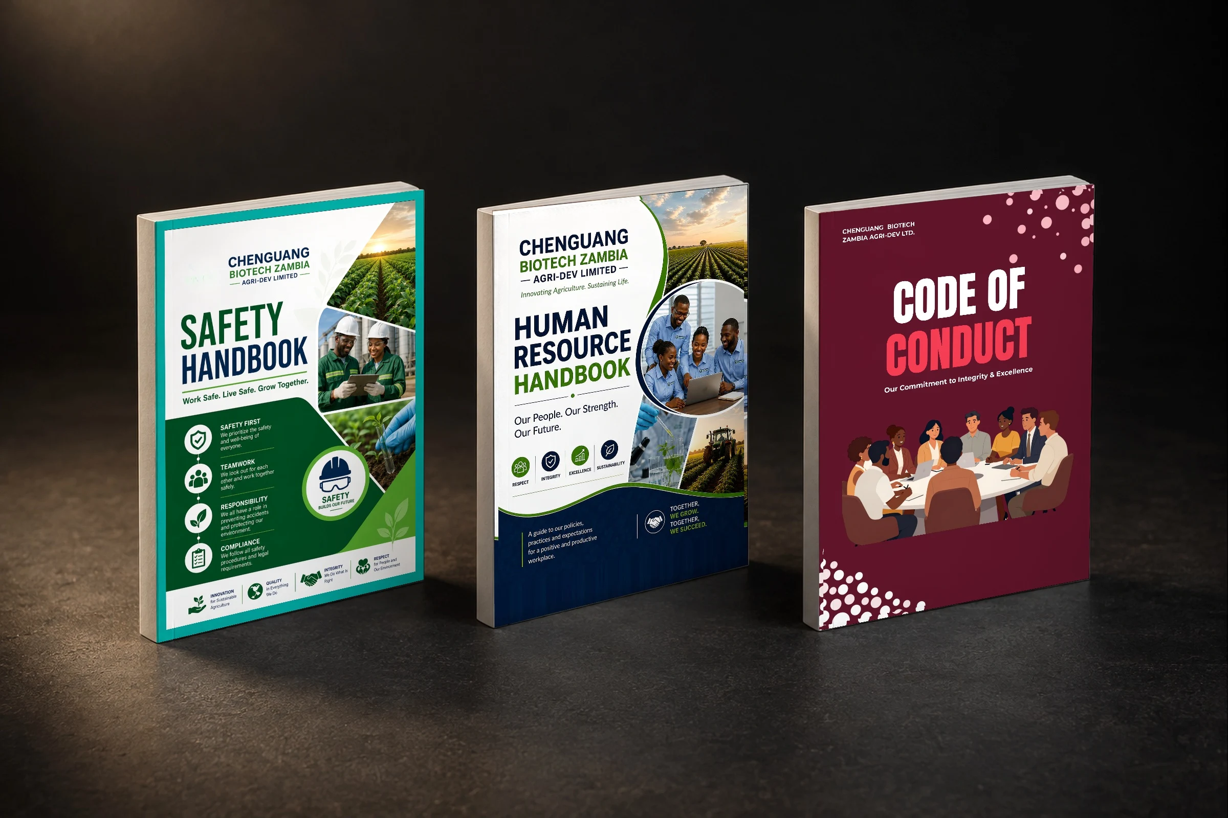 Three handbooks from the Chenguang Biotech HR document suite standing on a dark floor: Safety Handbook, Human Resource Handbook and Code of Conduct